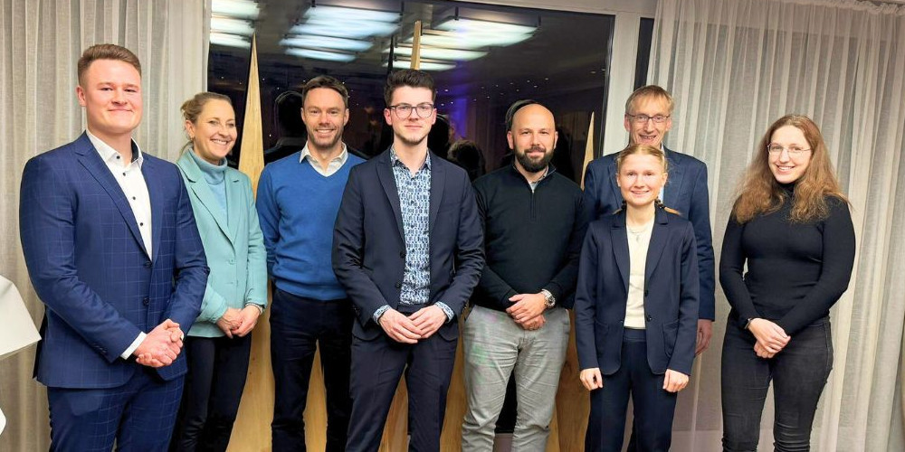 Copyright: Annika Buscha Bildunterschrift / ALT-Text: In the photo: award winners Constantin Mennes (far left), Benjamin Y. Koch (center left), Gina Dietterich, and Anna Fenja Tautz (1st and 2nd from right), their supervisors Lorenz Graf-Vlachy, Christiane Pott (2nd and 3rd from left), and Andreas Hoffjan (2nd from right in the back), and the award sponsor Steffen Leininger (center right). Supervisor Maren Kaliske is not pictured.